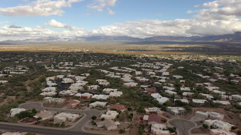 Clouds-cast-shadows-of-Arizona-town,-aerial-with-mountain-view