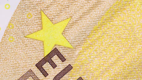 fifty-euro-bill-surface-detail-of-printed-letters-and-star-rotating,-macro-shot
