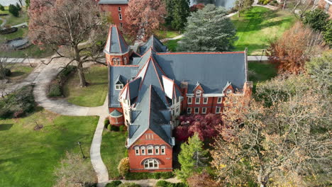 Aerial-tilt-down-on-Gothic-architecture-building-on-college-university-campus-during-autumn
