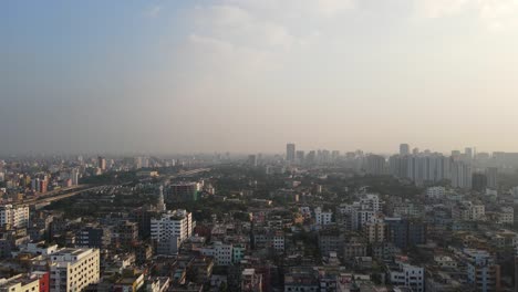 Descending-drone-shot-with-views-of-Dhaka's-polluted-skyline,-Bangladesh