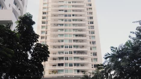 Toma-Panorámica-Inclinada-De-Un-Moderno-Condominio-Residencial-De-Gran-Altura-En-El-Corazón-De-La-Ciudad-Metropolitana,-Ciudad-De-Panamá