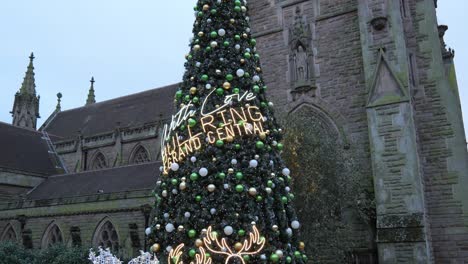 Happy-child-sitting-posing-under-Birmingham-Bull-ring-church-Christmas-tree-illumination