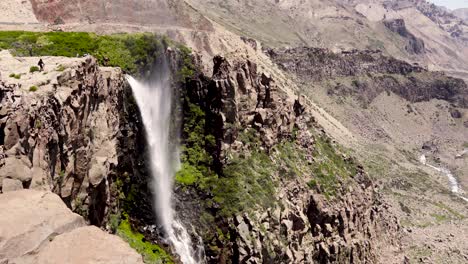 General-view-of-the-inverted-waterfall-being-strongly-driven-by-the-wind-and-with-its-surrounding-cliff-represented-by-the-aridity-of-the-mountains-of-central-Chile