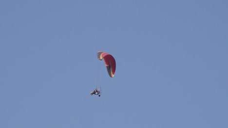 Competitive-Paraglider-Gliding-Against-A-Blue-Sky,-Sport-Competition