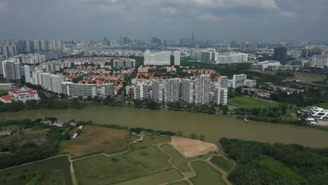 Ultra-modern-city-development-with-residential-and-commercial-high-rise-buildings,-villas,-green-space-and-river