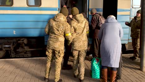 Soldaten-Und-Polizisten-Helfen-Ukrainischen-Flüchtlingen,-In-Einen-Zug-Zu-Steigen-Und-Sich-Vor-Dem-Krieg-In-Sicherheit-Zu-Bringen