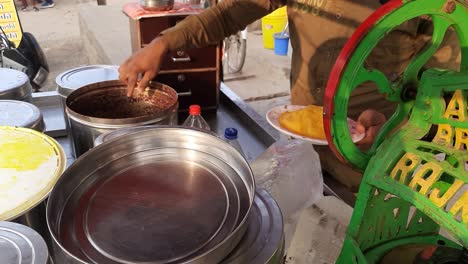 Chuski-Zubereitung-–-Ein-Mann-Macht-Das-In-Indien-Berühmte-Eis-Am-Stiel-Oder-Kala-Khatta-Mit-Zerstoßenem-Eis,-Dem-Später-Zitrone-Und-Aromatisierte-Lebensmittelfarben-Hinzugefügt-Werden