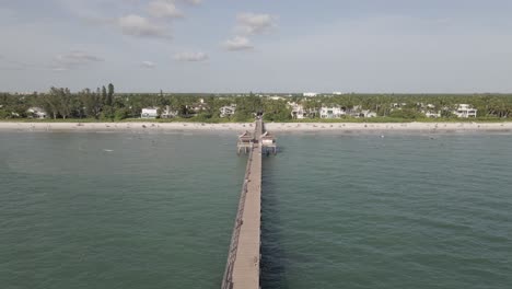 Aerial:-Naples-fishing-pier-almost-empty-on-warm-sunny-beach-day