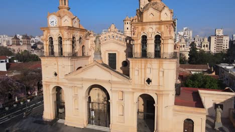 Aerial-tilt-up-shot,-drone-flying-toward-cathedral-of-Cordoba-in-Plaza-San-Martín,-capturing-the-close-up-exterior-details-of-historical-baroque-style-architecture