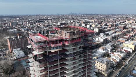 A-high-angle-view-above-a-building,-still-in-the-process-of-being-built-in-Brooklyn,-NY-with-NYC-and-Verrazano-in-the-distance
