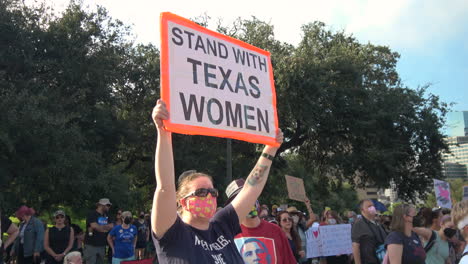 Woman-holds-STAND-WITH-TEXAS-WOMEN-protest-rally-sign-during-Women's-March-in-Austin,-TX
