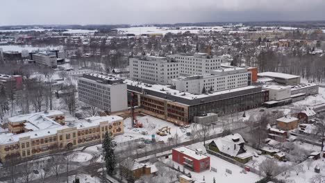 Drone-shot-of-Tartus-Maarjamõisa-hospital-during-winter,-180-degrees-shot-of-it
