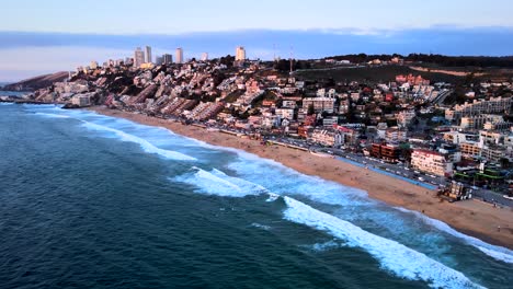 Panoramic-aerial-view-of-Reñaca-at-sunset-with-its-buildings-and-the-coastline-of-its-beach