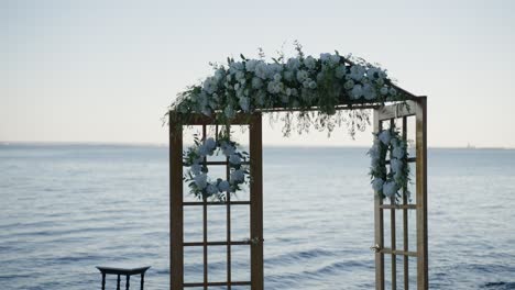 Wedding-ceremony-arrangement-on-the-shoreline-of-a-large-body-of-water
