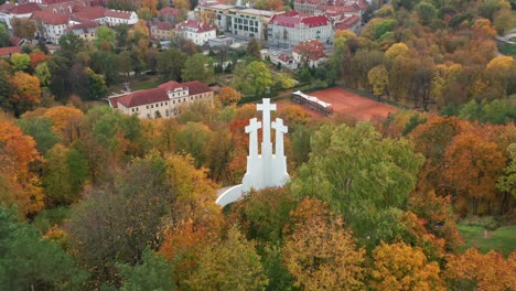 AERIAL:-Reveal-Shot-of-The-Hill-of-Three-Crosses-with-Vilnius-City-Panorama-in-Autumn