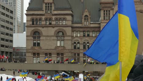 Close-Up-Of-Ukrainian-Flag-Flying,-Carried-By-A-Demonstrator-At-The-Nathan-Phillips-Square-During-Pro-Ukraine-Rally-In-Canada
