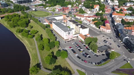 Aerial-View-of-Shopping-Mall-Building,-Parking-and-Riverside-Park-in-Downtown-Neighborhood-of-Kaunas,-Lithuania,-Drone-Shot