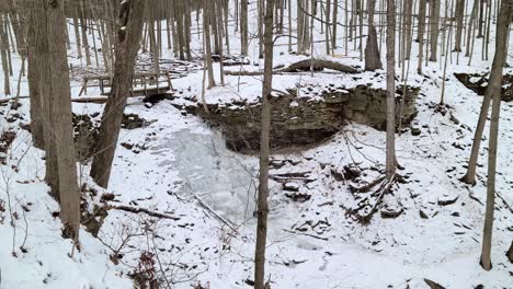 Frozen-waterfall-and-forest-river-in-cold-white-winter,-pan-right-view