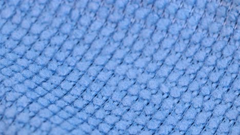 Macro-shot-of-the-material-of-a-blue-dishcloth,-macro-shot-close-up-detail-view-rotating-motion