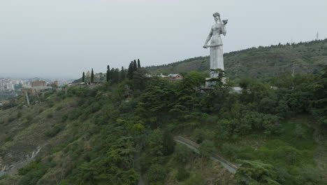 Dolly-in-aerial-shot-of-the-Kartlis-Deda-monument-and-Tbilisi-cityscape