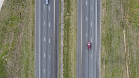 Cars-and-trucks-driving-on-a-divided-highway-while-the-camera-looks-straight-down