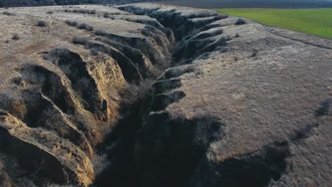 Flying-forward-drone-shot-over-a-canyon-in-loess-soil-at-the-Allah-Bair-nature-reservation-located-in-Constanta-County,-Dobrogea-region-of-Romania
