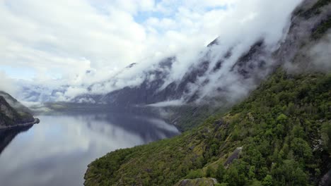 Aerial-View-Of-Smooth-Reflective-Lake-Eidfjordvatnet-With-Clouds-Rolling-Down-Valley