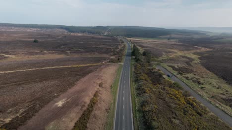 Aerial-view-above-long-straight-road-through-rural-Goathland-North-Yorkshire-peaceful-moors-countryside