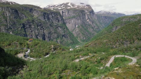Luftaufnahme-Der-Kurvenreichen-Bergstraße-Im-Hardangervidda-Nationalpark-Mit-Massiven-Klippen-Im-Hintergrund