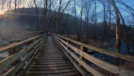 Crossing-a-pedestrian-wooden-footbridge-over-a-beautiful-stream-in-the-appalachian-mountains