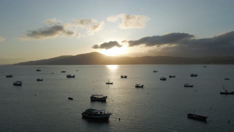 Sunset-Bay-with-Small-Boats-Anchored-near-the-Beach,-Aerial-Pullback