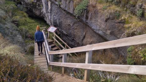 Slider,-person-descends-stairs-to-Luxmore-Cave,-Kepler-Track-side-trip,-New-Zealand