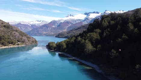 Top-aerial-drone-panoramic-view-Beautiful-mountains-landscape-and-a-cristal-clear-river-along-gravel-road-Carretera-Austral-in-southern-Patagonia,-Chile