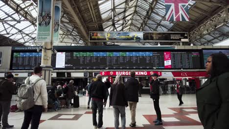 Inside-View-Of-Commuters-Looking-At-Departure-Board-At-Victoria-Train-Station-In-London-On-12-April-2022