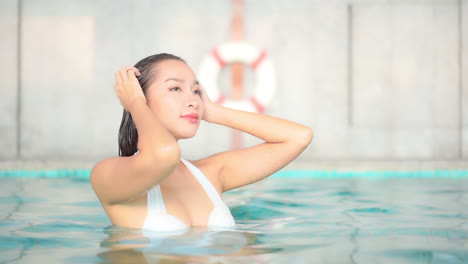 Hot-Attractive-Asian-Woman-Pushing-Back-Wet-Hair-In-Swimming-Pool---bust-shot