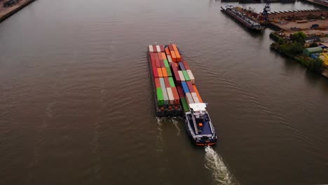Aerial-View-Over-Bridge-Over-The-Noord-Of-Maas-Push-Tow-Barge-Carrying-Cargo-Containers-Along-River-Passing-Through