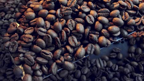 Stirring-an-scooping-coffee-beans-in-the-roaster---isolated-close-up-and-trickle-off-in-slow-motion