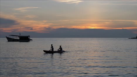 Majestic-video-of-the-silhouette-of-a-couple-kayaking-on-the-ocean-during-a-beautiful-sunset