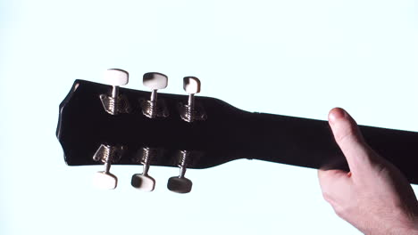 Mann-Spielt-Akustikgitarre,-Weißer-Heller-Hintergrund,-Nahaufnahme-Am-Nacken-Und-An-Der-Hand-Des-Mannes