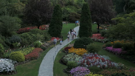 A-panning-shot-overlooking-intricate-flowerbeds,-landscaping,-and-people-in-the-Butchart-gardens