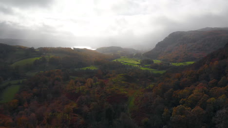 Aerial-footage-from-Yew-Tree-Tarn-in-Cumbria-heading-towards-Coniston-Water-over-woodland-in-its-autumn-colours