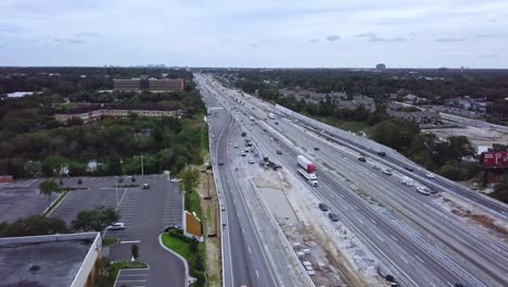 Slow-forward-moving-aerial-drone-shot-of-busy-highway-showing-vehicular-traffic