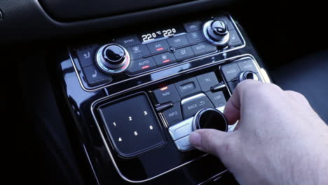 Hand-operating-luxury-car-console-close-up