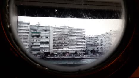 View-of-Thessaloniki-shore-as-seen-through-a-porthole-on-a-ship