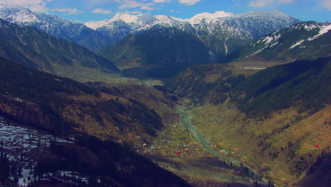 A-picturesque-village-with-beautiful-watery-scenes-round-snowy-mountains-and-river,-as-well-as-charmingly-crafted-greenery