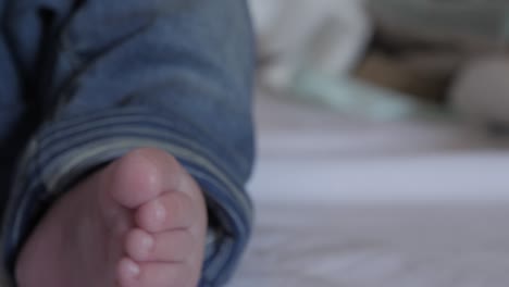 Close-up-of-baby-feet-as-he-wiggles-his-legs-and-toes