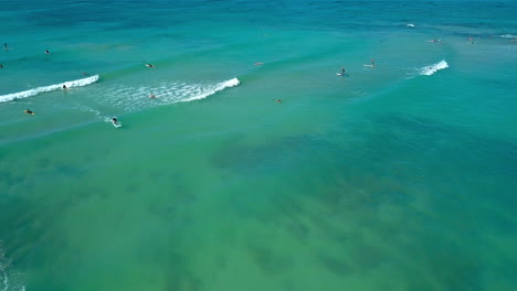 Drone-footage-of-surfers-off-of-Waikiki-Beach-on-the-island-of-Oahu,-Hawaii