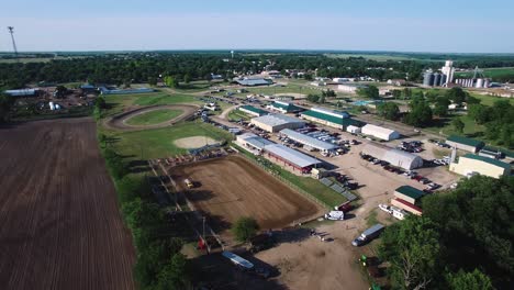 Aerial-pan-from-water-truck-wetting-down-the-dirt-arena-to-the-large-rodeo-grounds-and-Midwestern-prairie-landscape