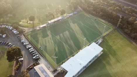 Rising-aerial-drone-footage-into-the-sun-of-a-men's-premier-league-field-hockey-match-at-Elgar-Park