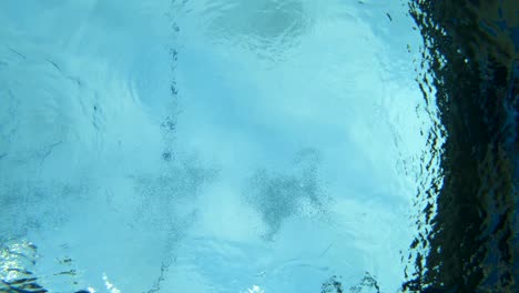 Unterwasseraufnahme-Einer-Frau,-Die-Mit-Voller-Geschwindigkeit-In-Ein-Schwimmbad-Taucht